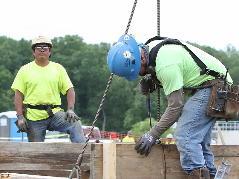 Construction workers setting a beam