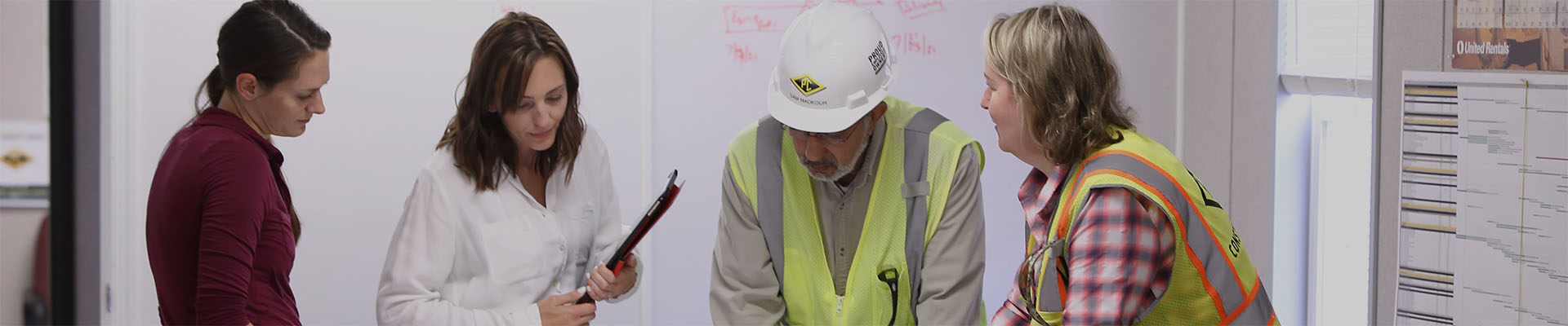 people looking down at plans on a table